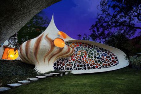 Mexico - Giant Seashell House - This giant seashell house is located in Mexico City, and was built and designed by Arquitectura Organica's own Javier Senosiain. The home was built back in 2006, and features a smooth front facade met with a giant wall of colored mosaics, lighting up the living space in a stunning rainbow effect. Inspired by the work of Gaudí and Frank Lloyd Wright, the house is dominated by smooth surfaces, spiral stairs and natural plantings that makes it feel like you're living inside a shell. It's a real house built for a young family with two children who were tired living in a conventional home and wanted to change to one integrated to nature. Would you like to live in this house?