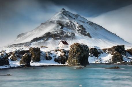 Arnarstapi, Iceland In Arnarstapi, a small village along the southern side of the Snæfellsnes peninsula, a lonesome red-roofed home sits at the base of Mount Stapafell. Could you live here?